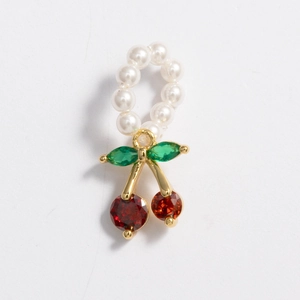Detail of cherry pendant on pearl ring with red and green cubic zirconia stones
