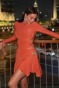 Détail de la robe orange à paillettes avec découpes sexy et cristaux scintillants