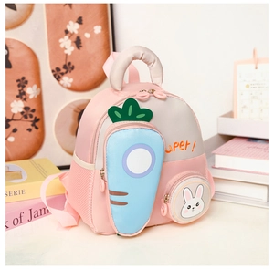 Detail view of pink cartoon kids backpack with carrot pocket and mesh side storage