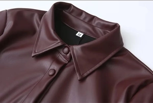 Details des dunkelroten PU-Lederjacken-Kragens und der Metalldruckknöpfe bei dieser M-Jacke