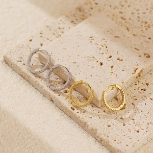 Detailed view of gold and silver S925 sterling silver hoop earrings with pavé crystals