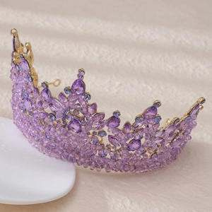 Detail shot of vintage baroque gold crown with sparkling purple crystals and rhinestones