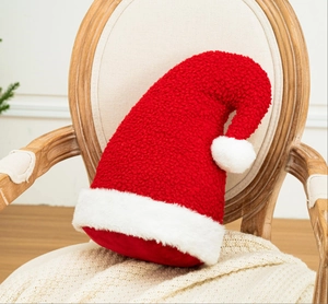 Coussin en forme de bonnet de Noël en polaire rouge sur un fauteuil vintage