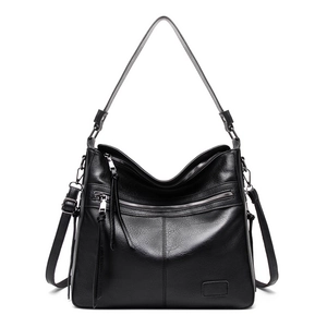 Detailed view of black pebbled leather tote bag with metallic zipper and shoulder strap