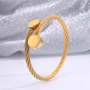 Detail of a 18k gold plated stainless steel wire bracelet with cylindrical ends