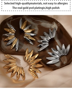 Detail of radial sunburst stud earrings with 18K gold PVD plating and polished finish