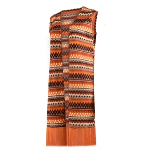Détail du gilet en maille bohème aux motifs vagues orange et longues franges au bas