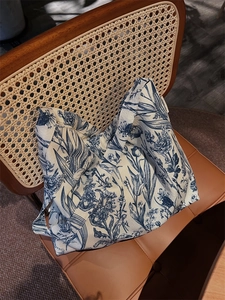 Detail of vintage blue floral cotton tote bag on a rustic chair with premium texture
