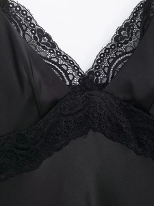 Détails de la dentelle et du satin soyeux sur la robe noire sexy avec col en V profond