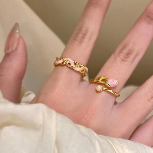 Close-up of 18k gold plated tulip ring with pink enamel chain on a model's hand