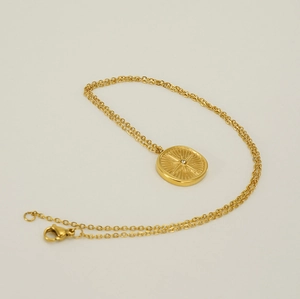 Macro shot of 18k gold plated starburst necklace with sparkling center zircon pendant