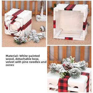 Detail of white painted wooden Christmas gift box set with festive red plaid bows