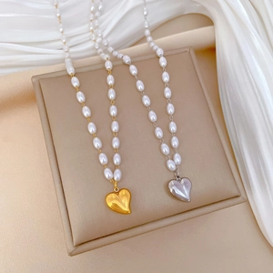 Detailed view of pearl necklaces featuring gold and silver 3D heart-shaped pendants