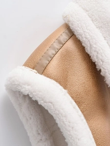 Detail of khaki leather and cream faux fur stitching on the fleece-lined vest