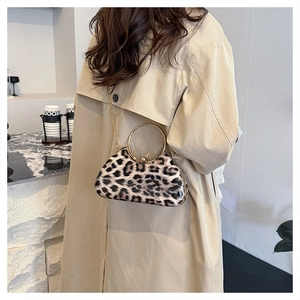 Detail of leopard print evening clutch with a golden ring handle and metal chain strap
