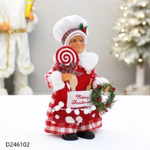Detail of Christmas chef doll with red checkered dress holding a lollipop and wreath