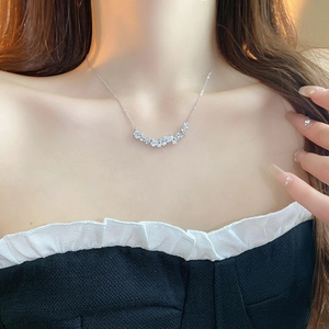 Close-up of minimalist silver necklace with pear-shaped cubic zirconia on a model
