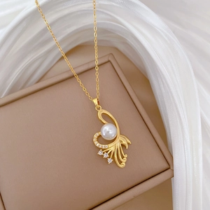 Macro shot of gold stainless steel necklace with pearl pendant and pavé rhinestones