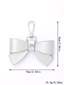 Silver leather bow keychain with crystal detail and 9cm dimensions on white background