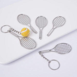 Mini metal tennis racket keychain with yellow felt ball charm on a clean white display