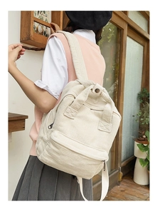 Rückansicht eines Models mit einem beigen Cord-Rucksack in einem professionellen Studio