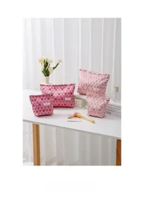 Detailed view of pink canvas cosmetic bags with heart patterns and gold zipper detail