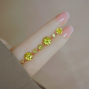 S925 sterling silver studs with yellow stones in various sizes shown on a finger