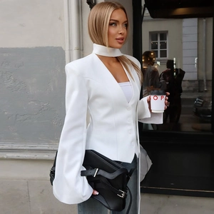 Detailed close-up of a white slim-fit blazer featuring a halter V-neck and button design