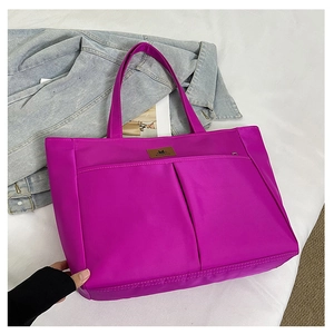 Detail of a purple large capacity nylon tote bag with two front pockets and logo