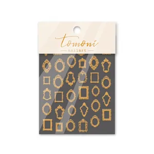 Macro detail of gold foil embossed nail stickers featuring vintage ornate frame designs