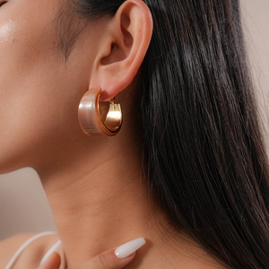 Close-up of a model wearing retro amber resin C-shape hoop earrings with gold metal base
