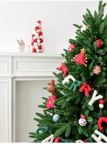 Close-up of wool felt Merry Christmas ornaments on tree with white fireplace background