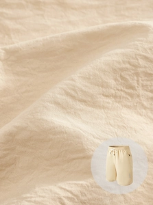 Detail of beige quick-dry fabric texture with a round inset showing the casual sports shorts