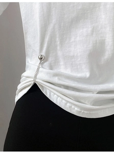 Close-up of magnetic metal chain buckle for T-shirt length adjustment on white cotton fabric