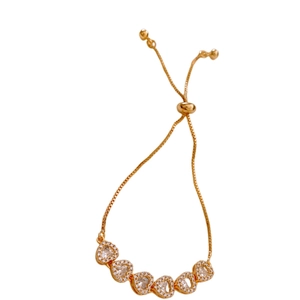Bracelet ajustable plaqué or avec six breloques cœurs en zircone sur fond blanc