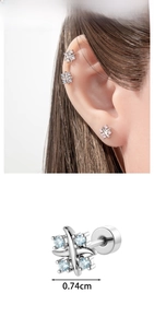 Macro detail of cross ear stud with zircon inlay and model wearing on the ear lobe