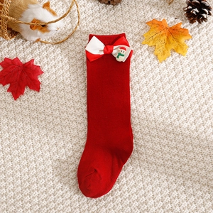 Festive red Christmas socks for babies with cute snowman and bow on a cozy knit background