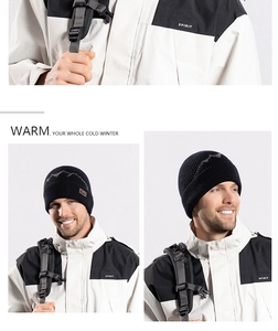 Close-up of black knit beanie with mountain pattern and leather logo tag for winter