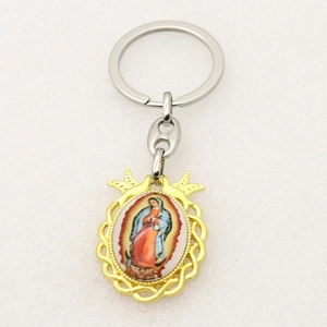 Detailed macro view of gold-tone Virgin of Guadalupe pendant on a metal keychain