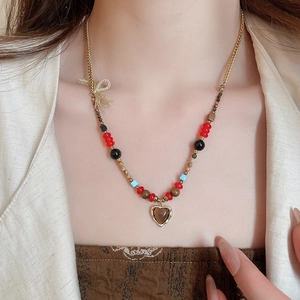 Detail of tiger eye heart pendant necklace with colorful beads on a model