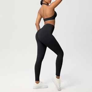 Vista laterale del reggiseno yoga nero e leggings a vita alta con effetto modellante