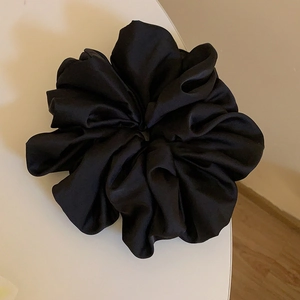 Oversized black satin scrunchie with soft silk luster shown on a clean white surface