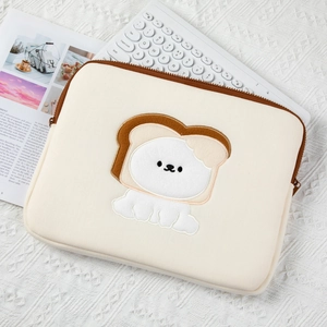 Detail of cute toast dog embroidery on a beige tablet sleeve over lace fabric