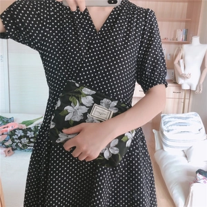 Mirror selfie showing the floral jacquard canvas clutch bag held in hand for daily style