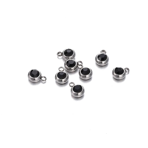 Vue détaillée de pendentifs argentés avec pierres de zircon noir et anneaux de suspension