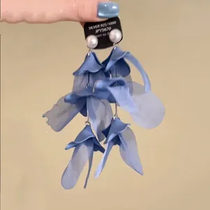 Detail of blue fabric flower drop earrings with white pearls and silver needles