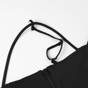 Dettaglio di un top in maglia nero con spalline di perle e cerniera in metallo