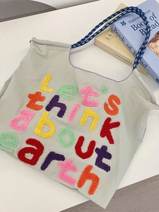 Minimalist canvas tote bag with embroidered Earth slogan and colorful rope handles
