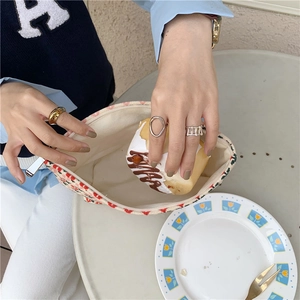 Gros plan d'une trousse de maquillage vintage en velours côtelé à motif cerise