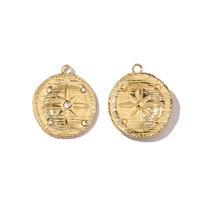 Macro detail of gold-plated celestial charms featuring starburst designs with inlay work